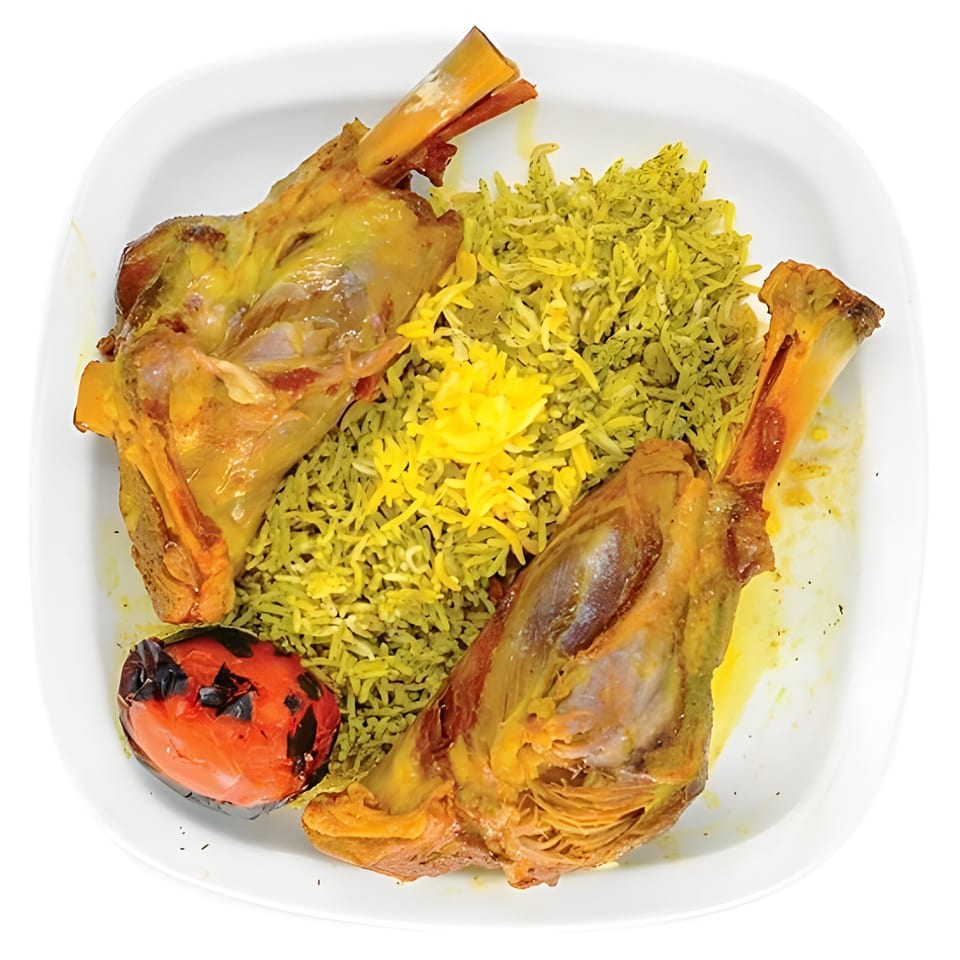 Two lamb shanks with green dill rice, saffron rice, and a grilled tomato on a white plate.