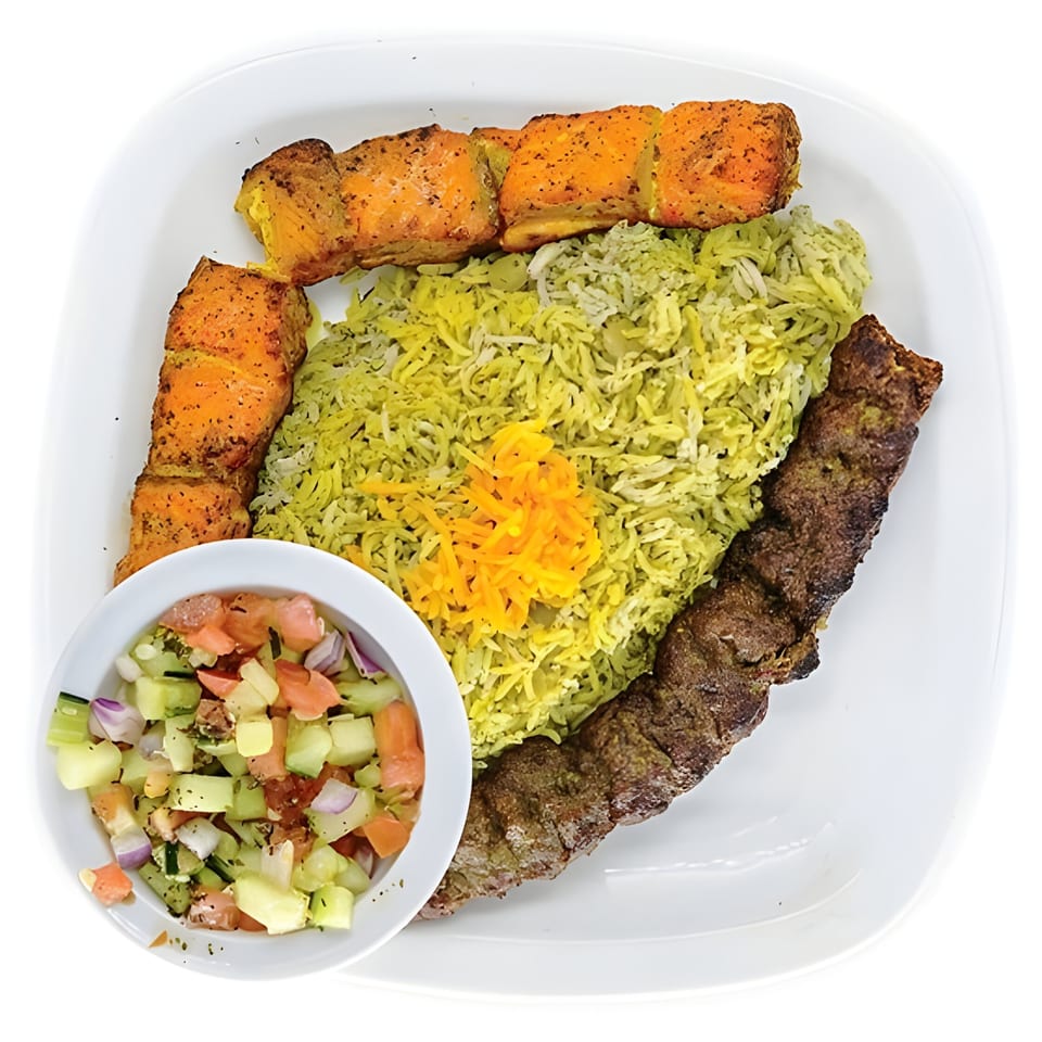 Persian dish with salmon and koobideh kabobs, dill rice, and Shirazi salad on a white plate.