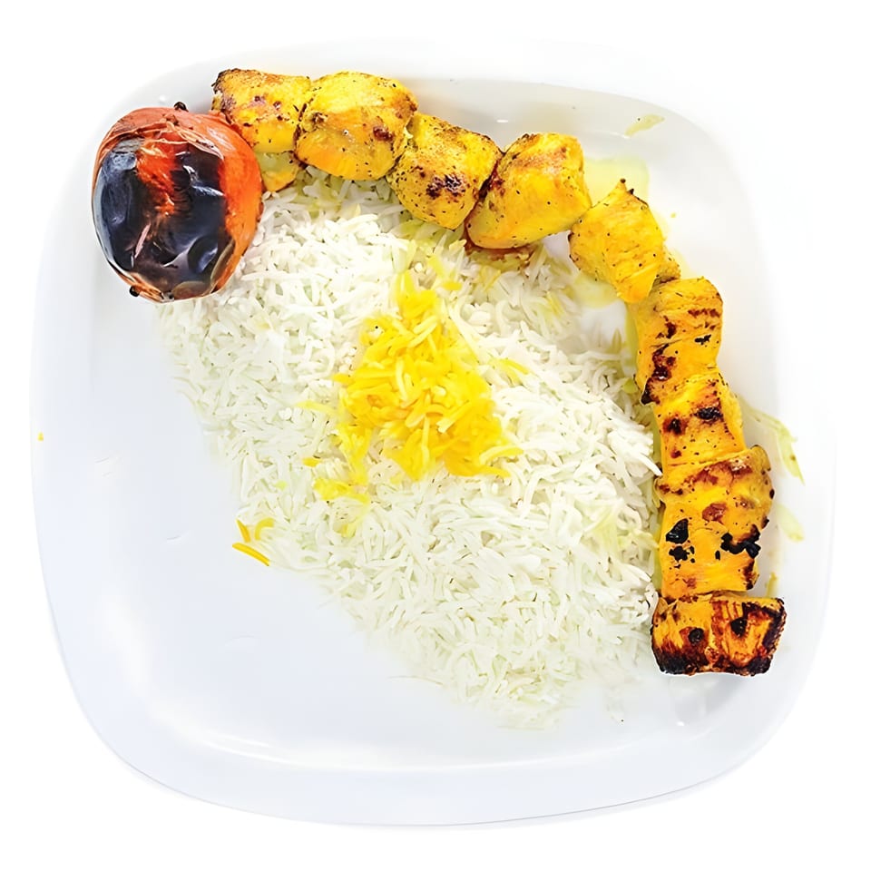 A plate of Persian chicken kabob with white rice, saffron, and a grilled tomato.